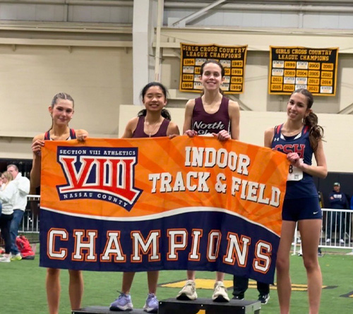 4 girls posing with the champion banner