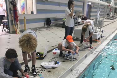 children at the pool testing robots