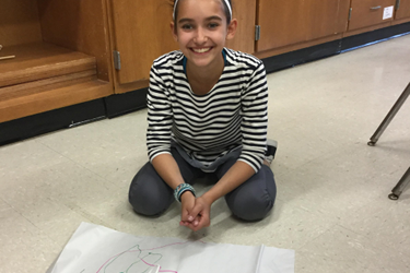 girl looking at camera with drawing