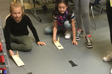 two girls testing a wooden car